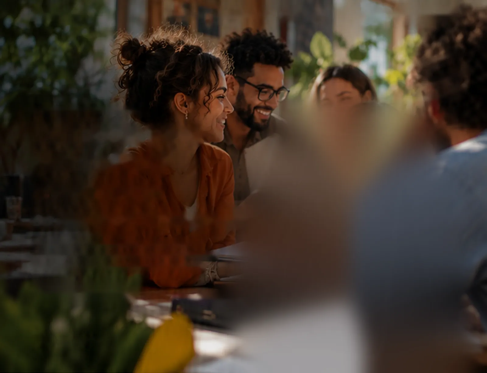 Des personnes réunies en terrasse échangent en souriant.